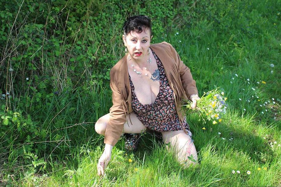 20P Older woman Mary Bitch picks a bunch of flowers while getting naked in a field