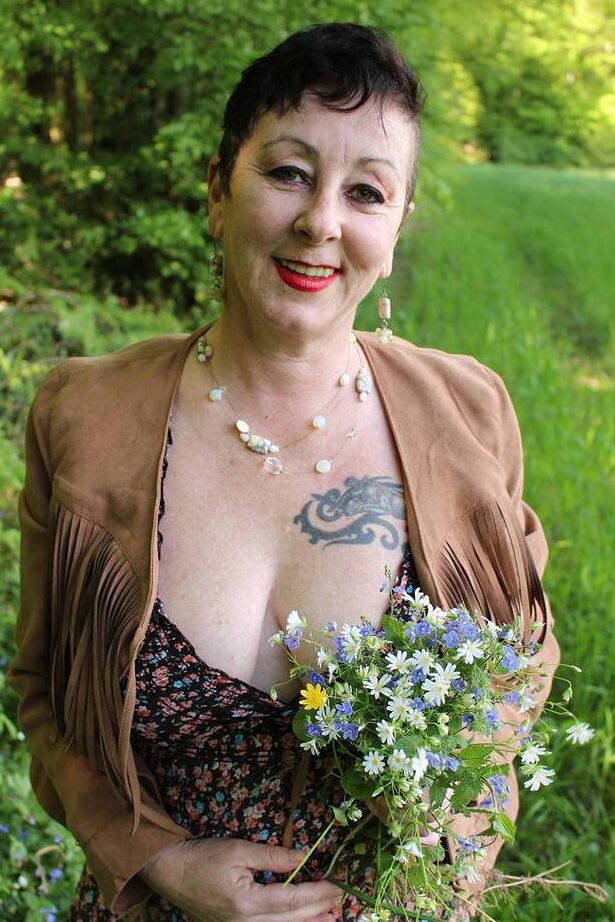 20P Older woman Mary Bitch picks a bunch of flowers while getting naked in a field