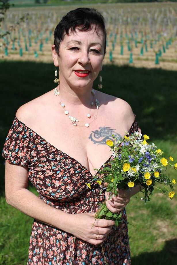 20P Older woman Mary Bitch picks a bunch of flowers while getting naked in a field
