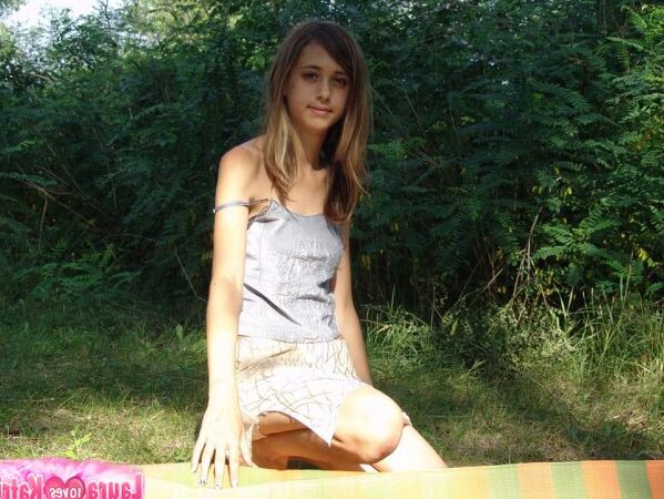 10P Une jeune fille expose son nombril sur une couverture près de quelques arbres