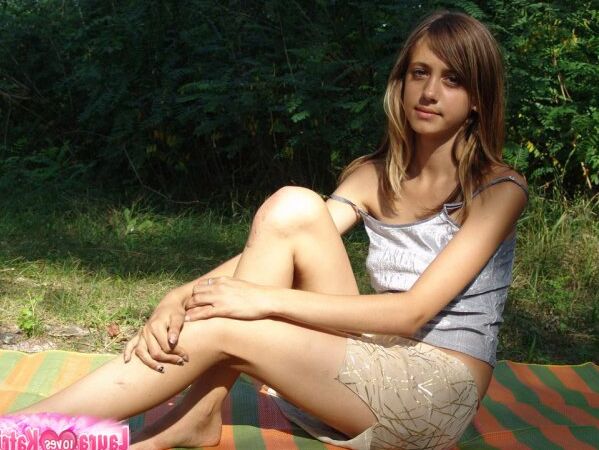 10P Une jeune fille expose son nombril sur une couverture près de quelques arbres