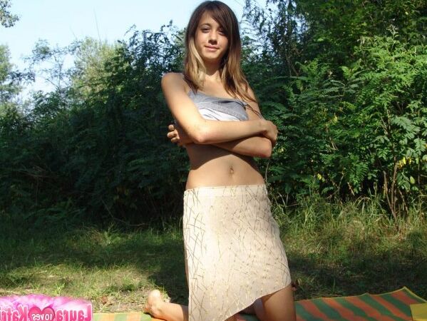 10P Une jeune fille expose son nombril sur une couverture près de quelques arbres
