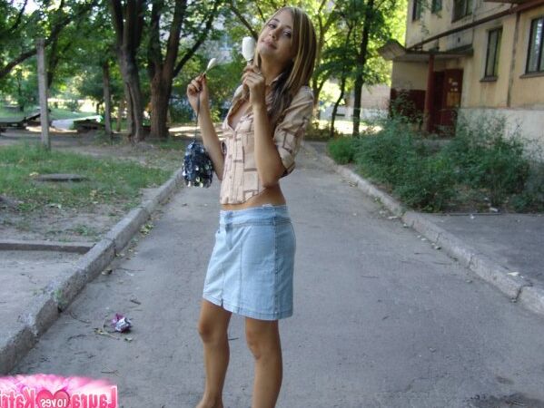15P Adolescente amateur muestra una falda bajo la falda sin bragas mientras come golosinas congeladas en la calle