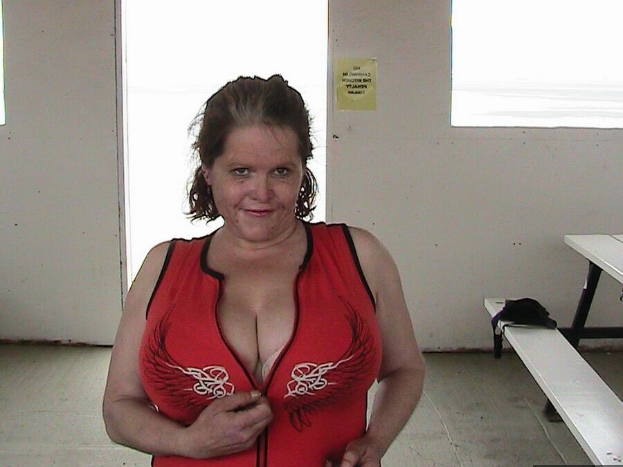 20P Older redhead Misha MILF displays her large tits by a lake before dildo riding