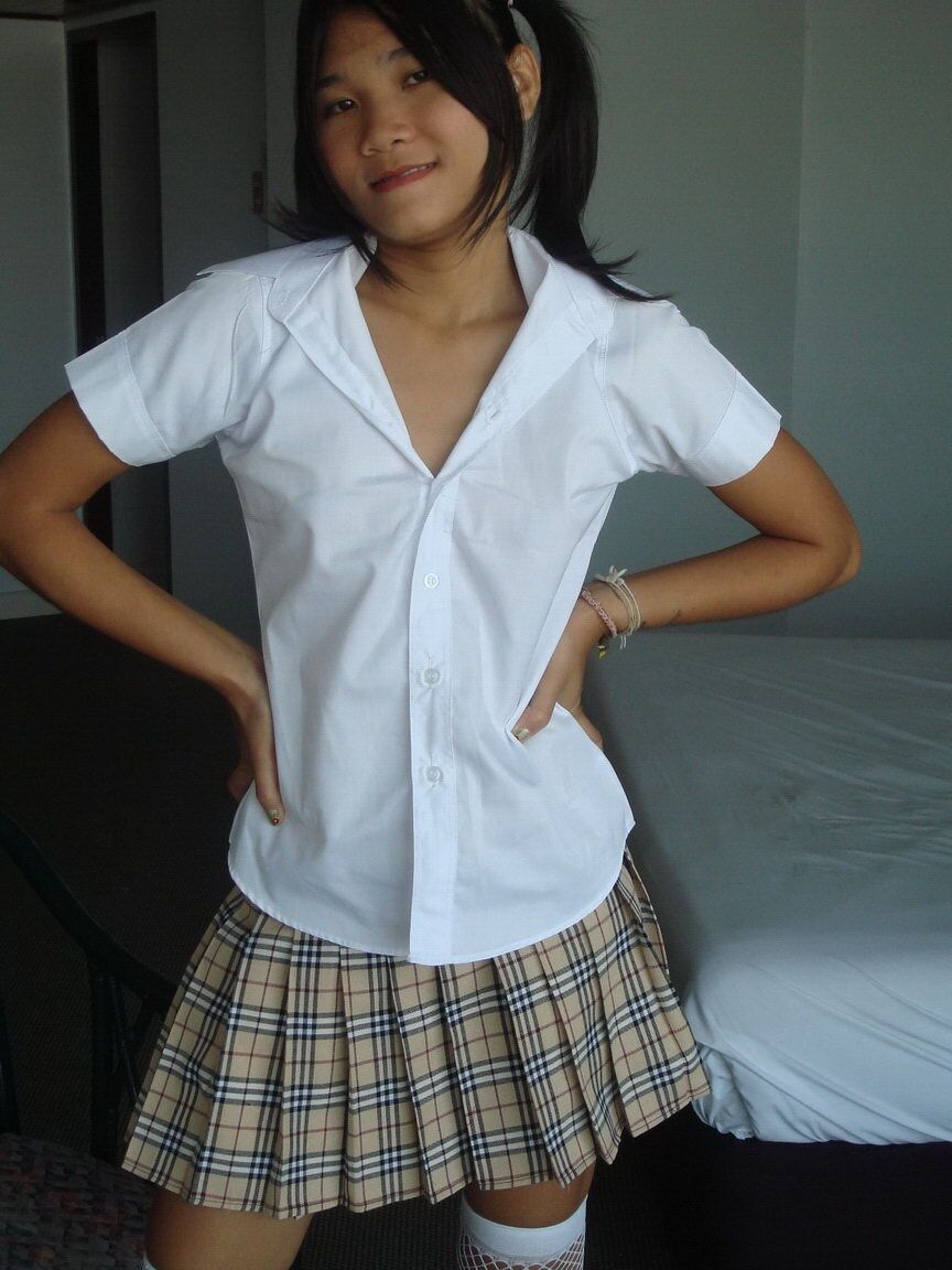 12P Une jolie adolescente asiatique montre sa chatte chauve avec des bas en maille et des nattes