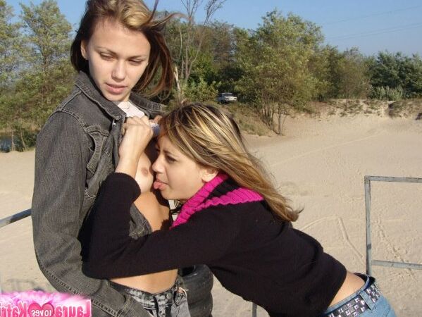 15P Young lesbians Lauraa and Katrina exposes their small tits while at the beach