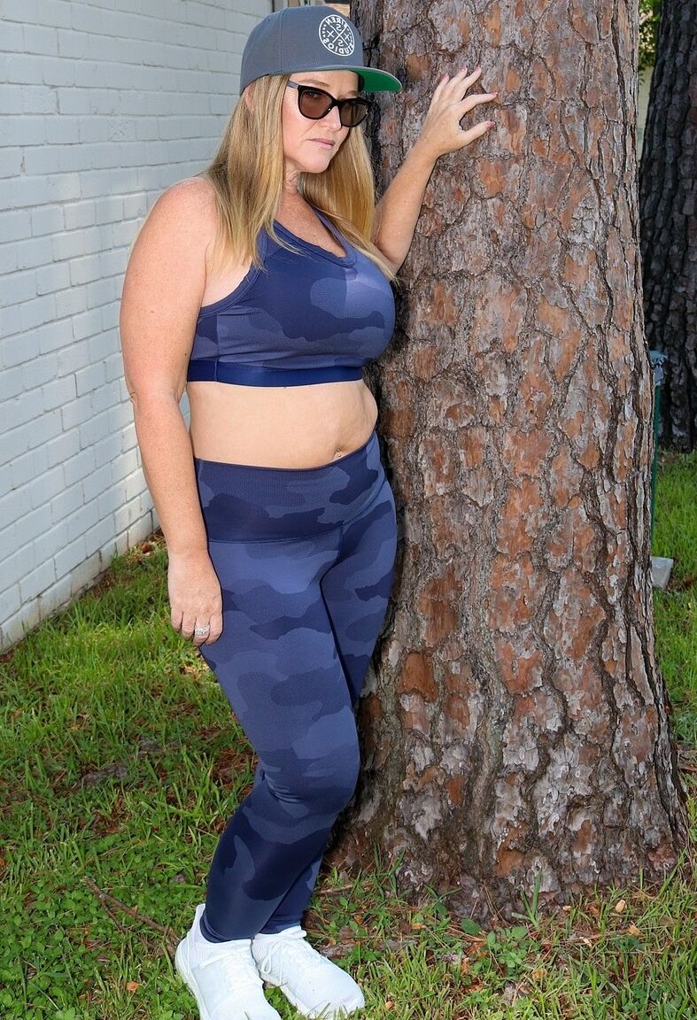 14P La puma bajita Dee Siren posando con sus sexys leggings y top en el jardín