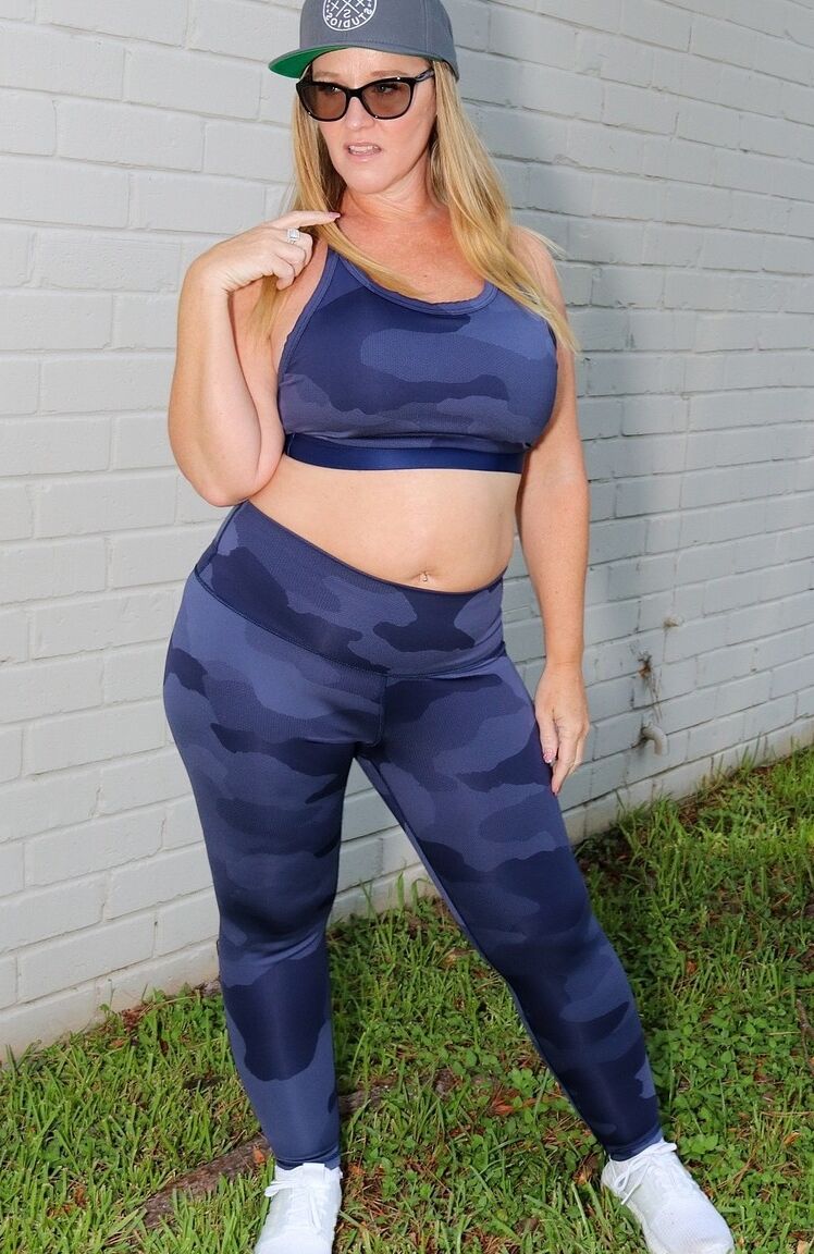 14P La puma bajita Dee Siren posando con sus sexys leggings y top en el jardín