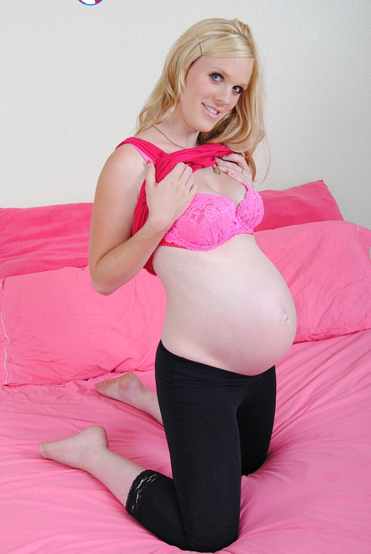 15P Pregnant blonde Kristi folds back her labia lips after getting naked on a bed