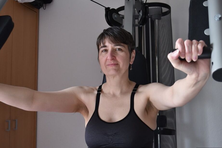 20P Fit older lady shows off her saggy tits while working out at the gym