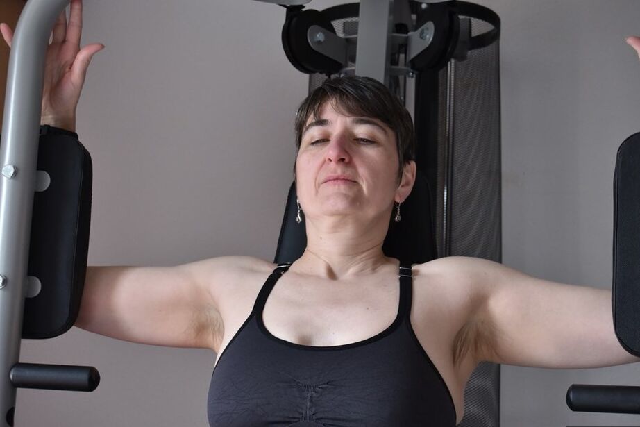 20P Fit older lady shows off her saggy tits while working out at the gym