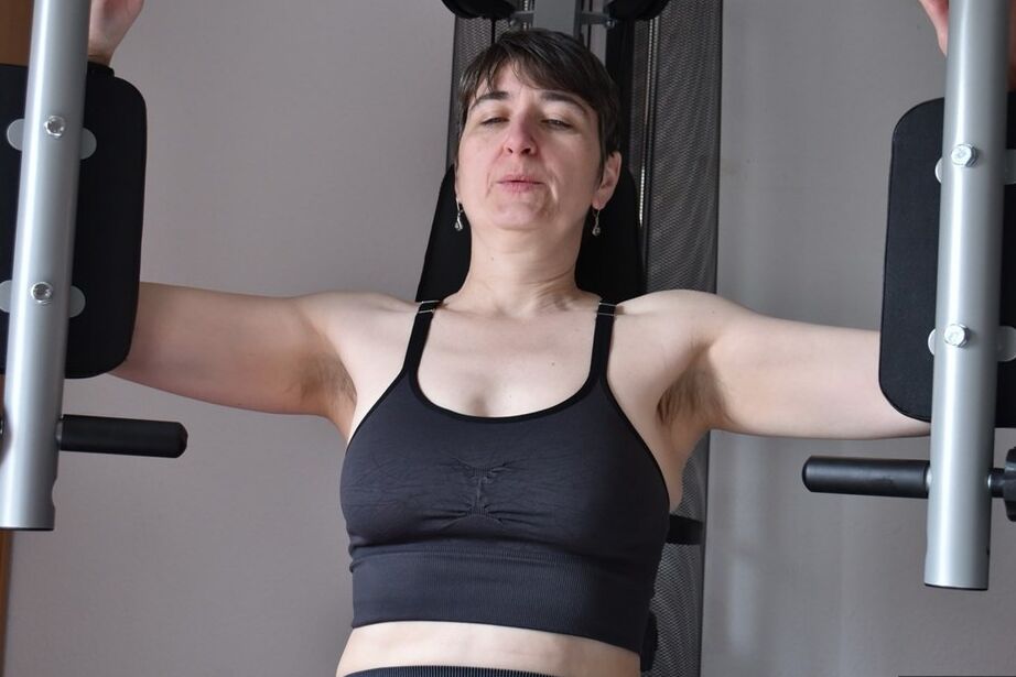 20P Fit older lady shows off her saggy tits while working out at the gym