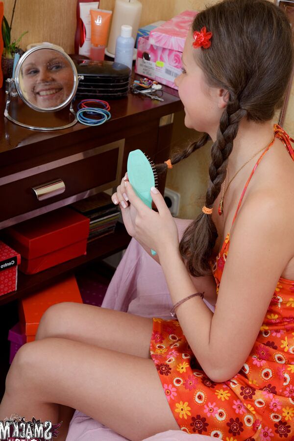 15P In red high heels, an orange and red dress, and braided pigtails Dulce sits in