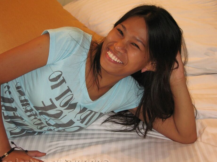 Die 17P Smiley Filipina Jenny macht einen Striptease, um ihre haarige Vagina auf dem Bett zu zeigen
