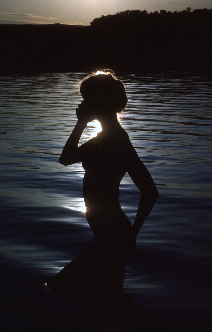 16P La blonde torride Monika Schebesta pose ses petits seins naturels au bord de l'eau