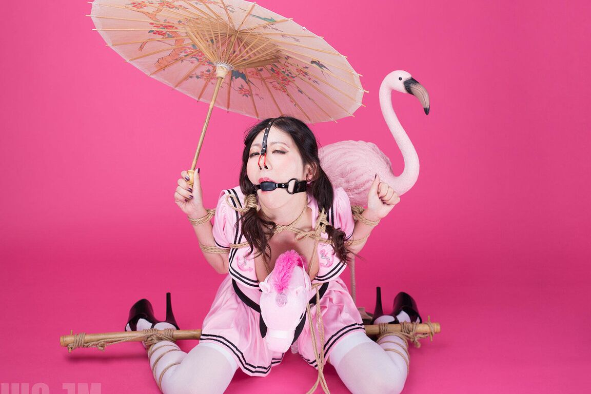 16P, Coco, une fille solo asiatique, tient un parasol après avoir été ligotée et bâillonnée.