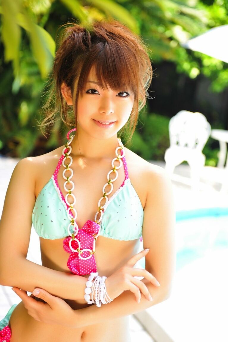 12P Adorable Japanese girl models a pretty bikini on a poolside patio