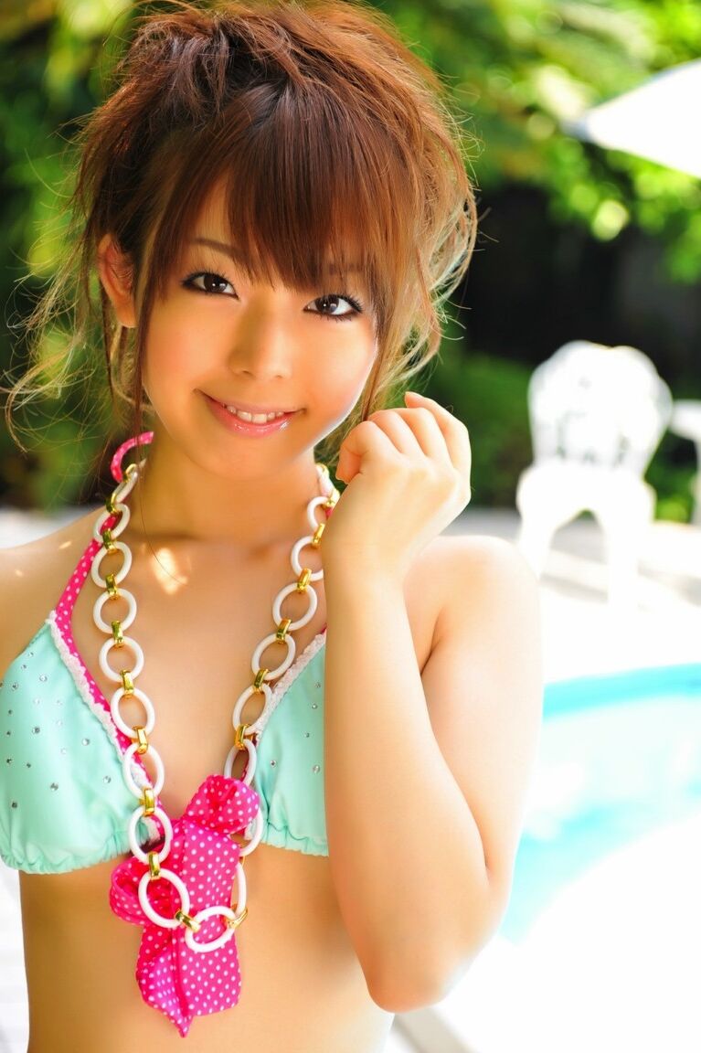 12P Adorable Japanese girl models a pretty bikini on a poolside patio