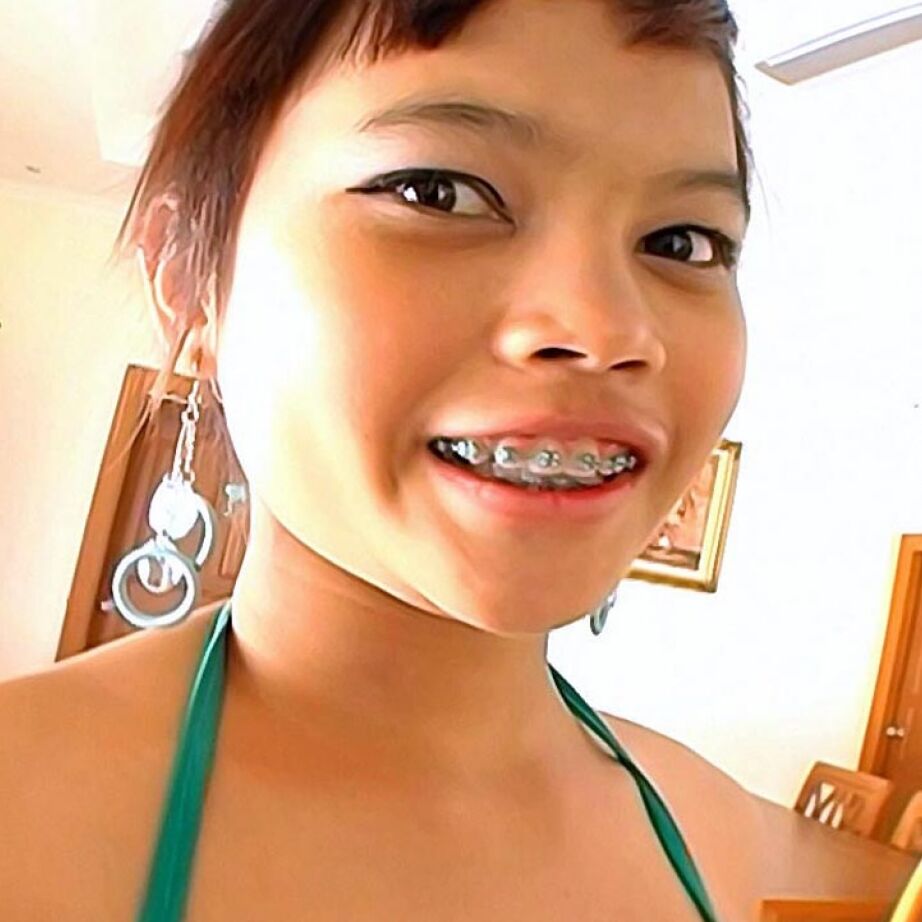 16P Une jeune fille asiatique montre son appareil dentaire tout en prenant une éjaculation bouche ouverte