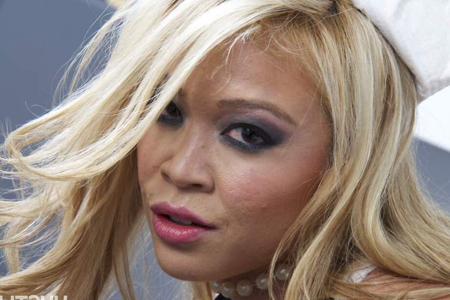 16P Blonde Asian Mia Lelani posing in white stripper boots with gun in hand