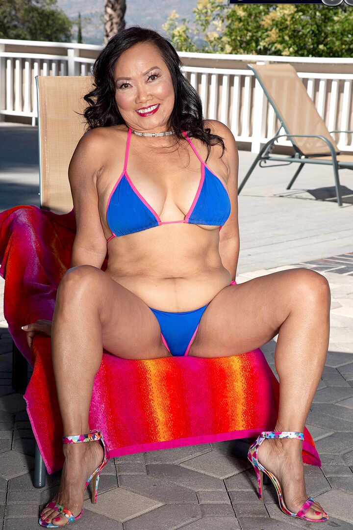 16P 70 plus La dama asiática Mandy Thai se quita el bikini para quedarse desnuda junto a la piscina al aire libre