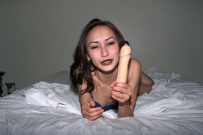 16P Petite Asian amador Tina brincando com um grande vibrador na cama de salto alto