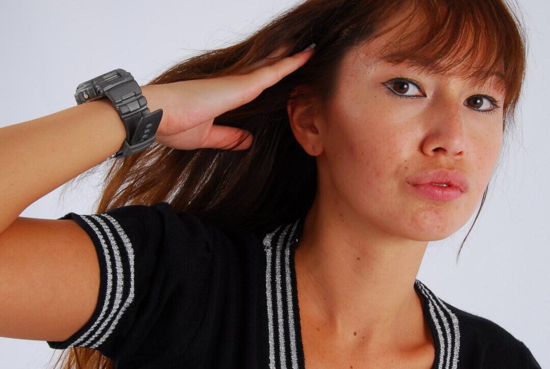 16P Asian redhead Evita models a grey G-Shock watch while fully clothed