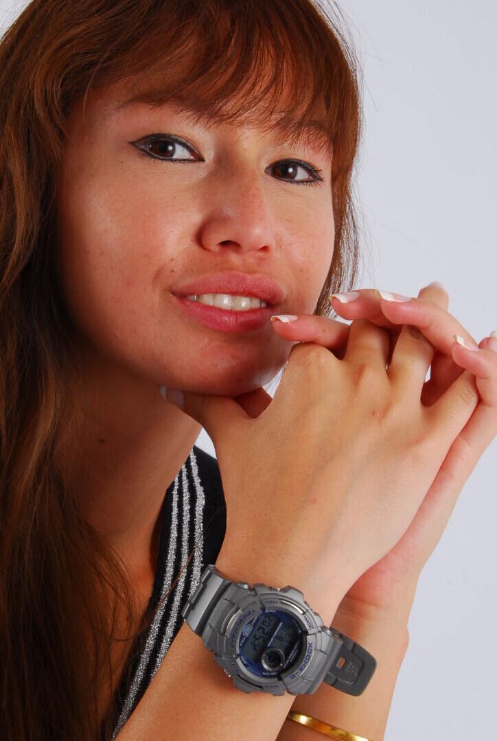 16P Asian redhead Evita models a grey G-Shock watch while fully clothed