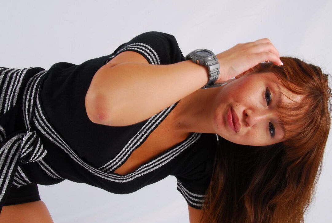 16P Asian redhead Evita models a grey G-Shock watch while fully clothed