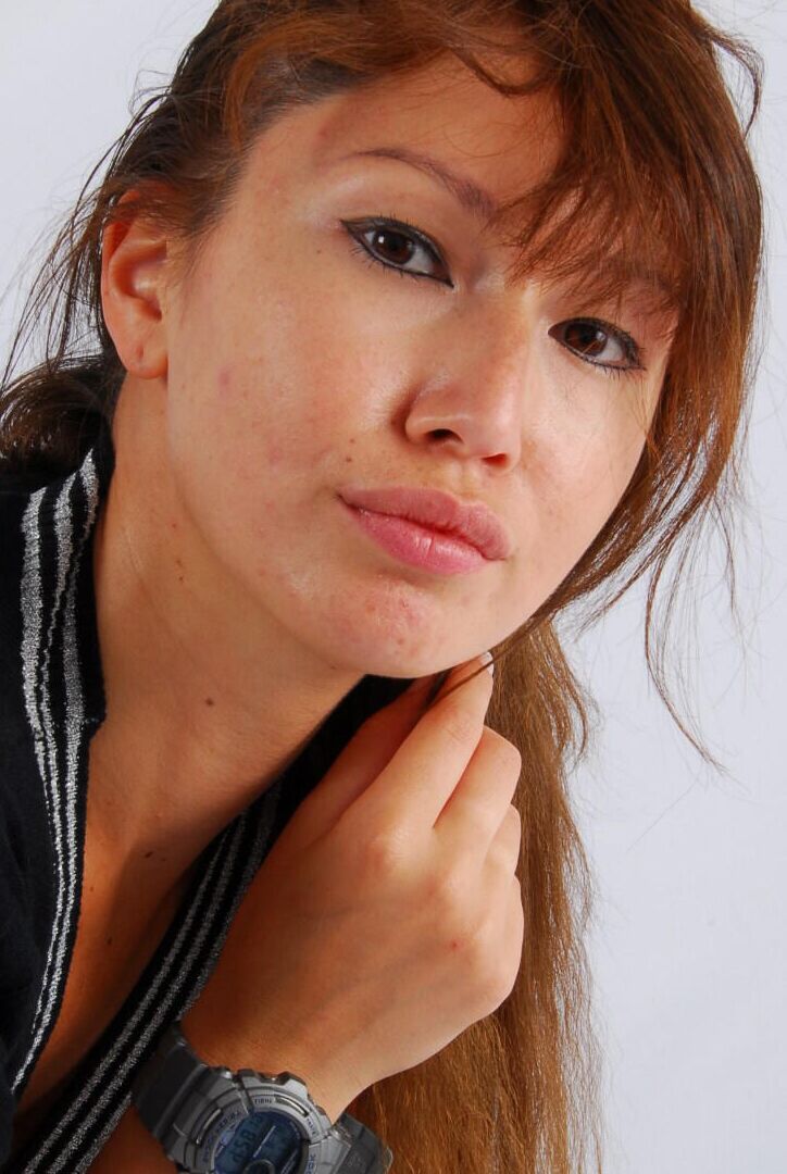 16P Asian redhead Evita models a grey G-Shock watch while fully clothed