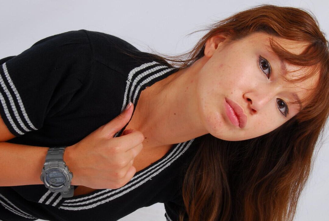 16P Asian redhead Evita models a grey G-Shock watch while fully clothed
