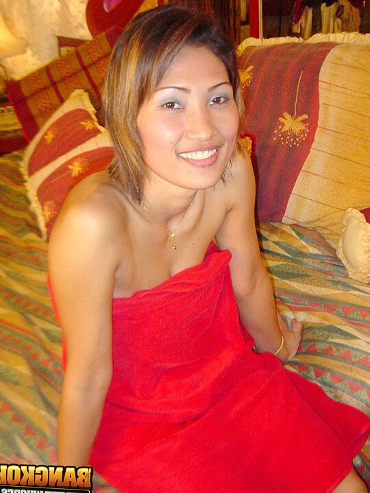 15P Esbelta tailandesa descubre sus tetas naturales mientras se quita el vestido rojo en la cama