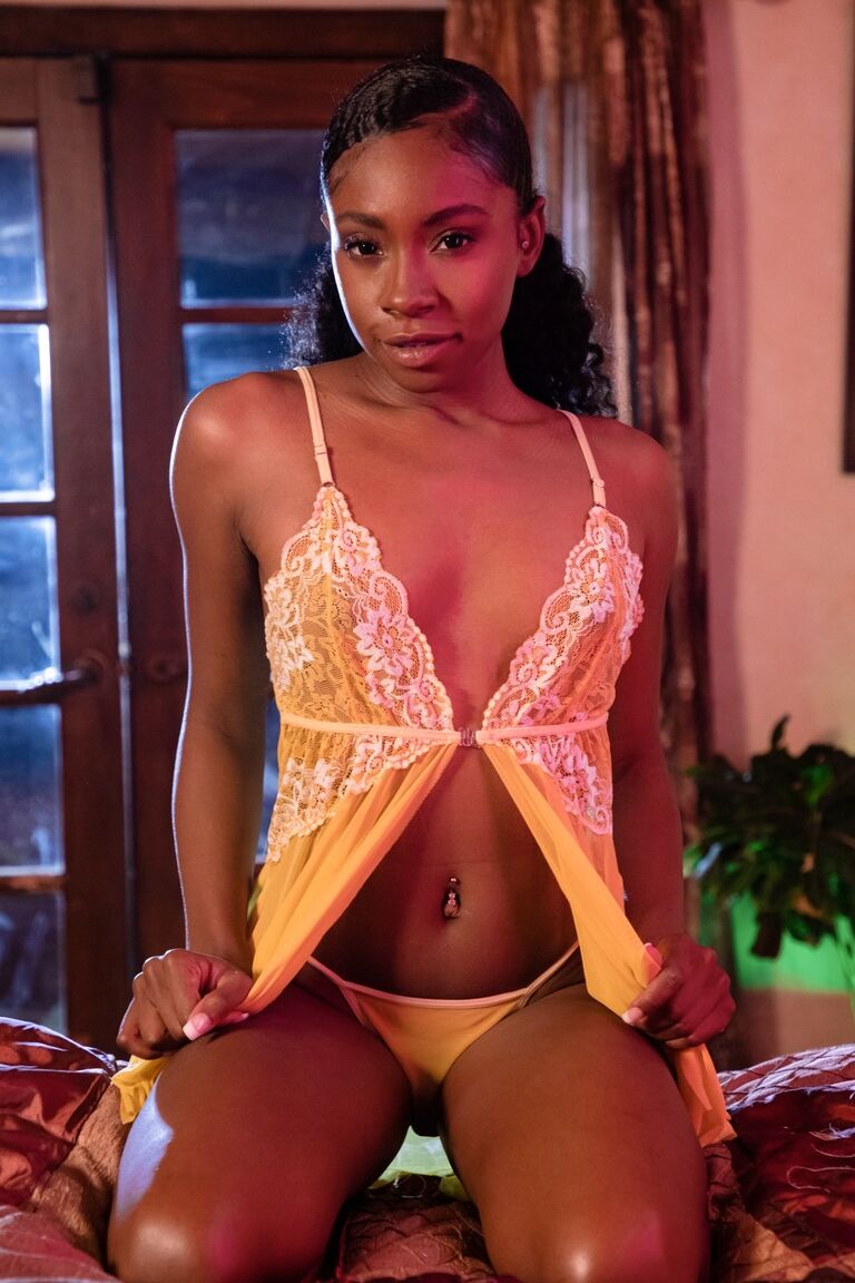 15P Ebony solo girl slips out of her lingerie to pose nude in front of a window