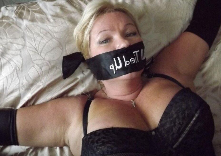 14P Busty older blonde is left tied up and gagged in numerous outfits