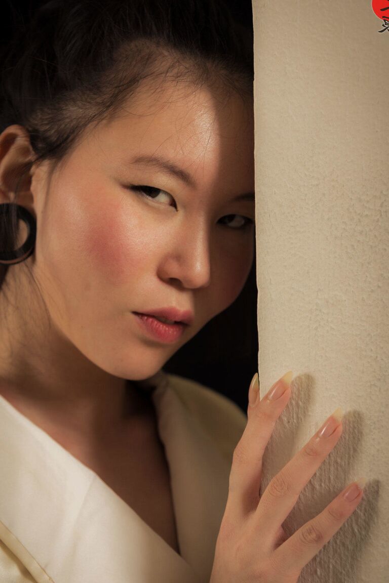 16P Asian model Flawless Meow is restrained with rope during a Shibari shoot
