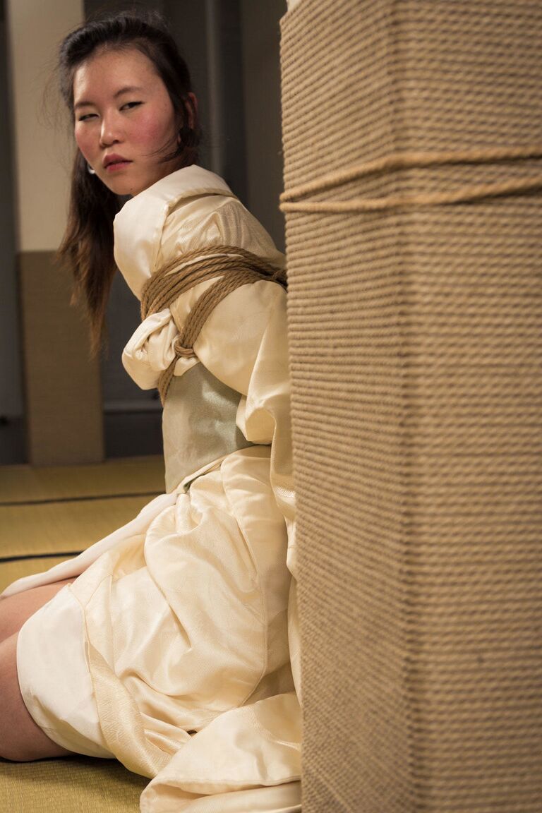 16P Asian model Flawless Meow is restrained with rope during a Shibari shoot