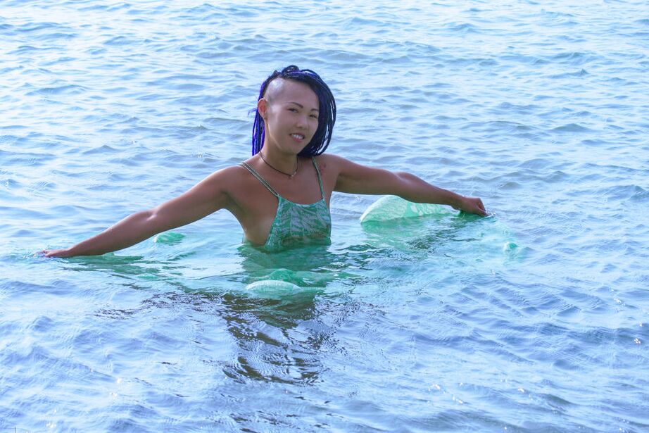 16P La chaude teen asiatique Sweet Julie enlève sa robe mouillée pour des poses nues dans l'eau