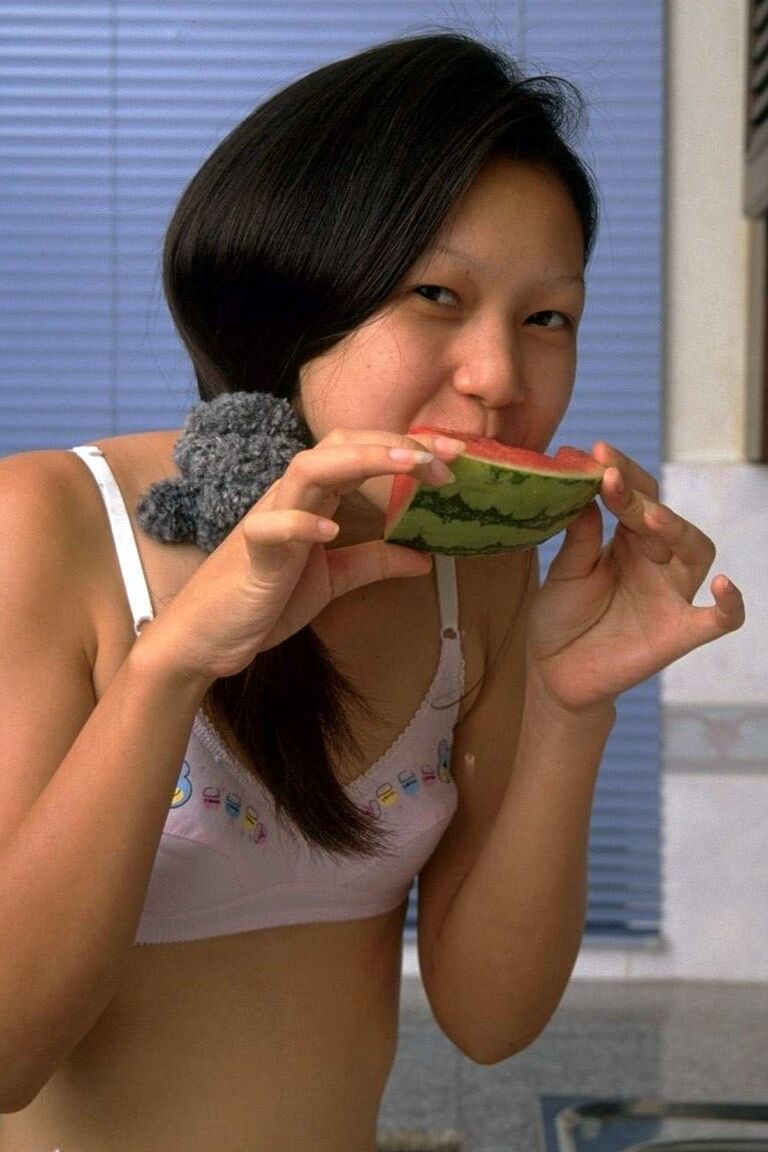 16P Une charmante adolescente asiatique enlève ses sous-vêtements en dentelle tout en mangeant une pastèque