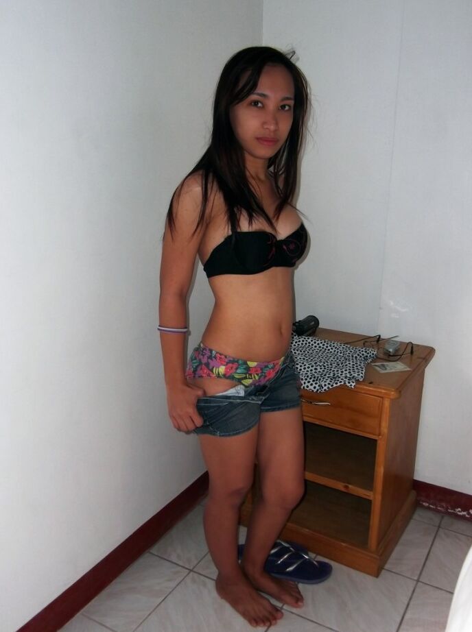 21P La petite Caren montre ses jolis seins naturels et pose nue dans une chambre d'hôtel.