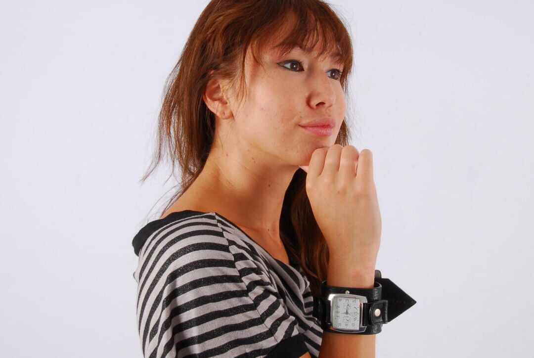 16P Asian redhead Evita glances at her huge Frilis watch while fully clothed