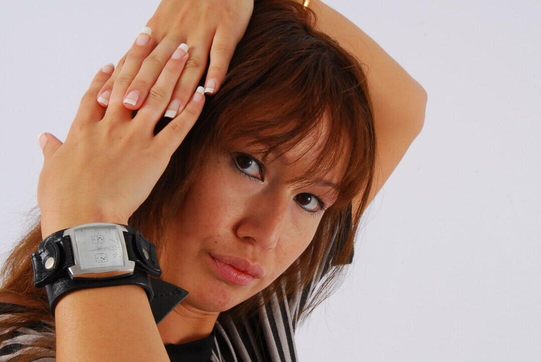 16P Asian redhead Evita glances at her huge Frilis watch while fully clothed