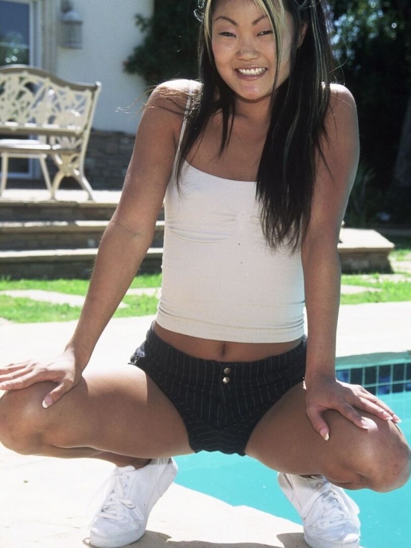 21P La chaude asiatique Lucy Lee montre ses petits seins et pose au bord de la piscine.