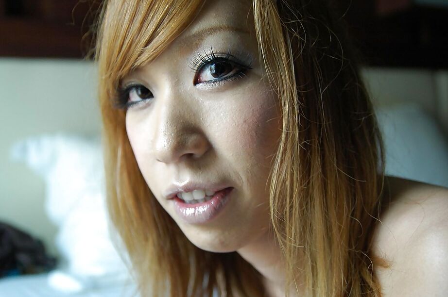 16P Adolescente asiática sonriente con el coño peludo Mana Utsumi posando desnuda en la cama