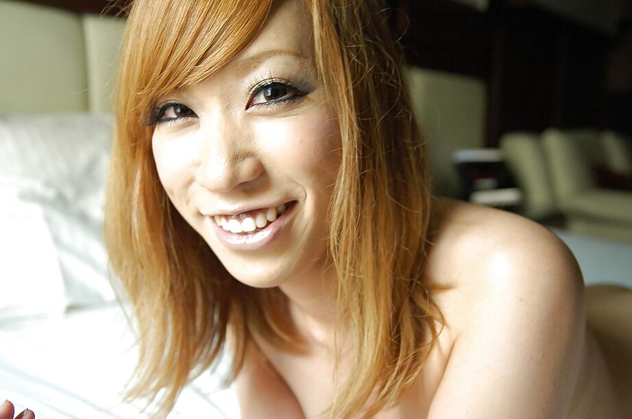 16P Adolescente asiática sonriente con el coño peludo Mana Utsumi posando desnuda en la cama