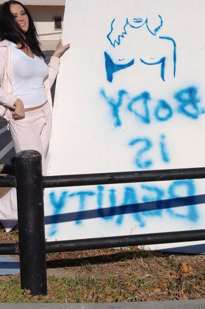 16P A garota asiática Dee Lily mostra seus peitos grandes ao ar livre em calças de ioga