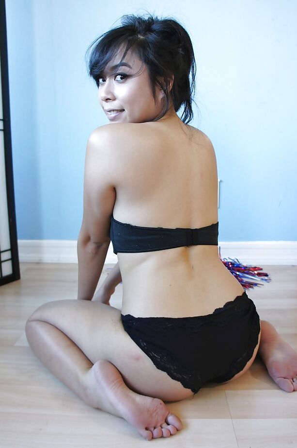 16P May Lee, petite pom-pom girl asiatique, pose dans un joli uniforme et des chaussettes.