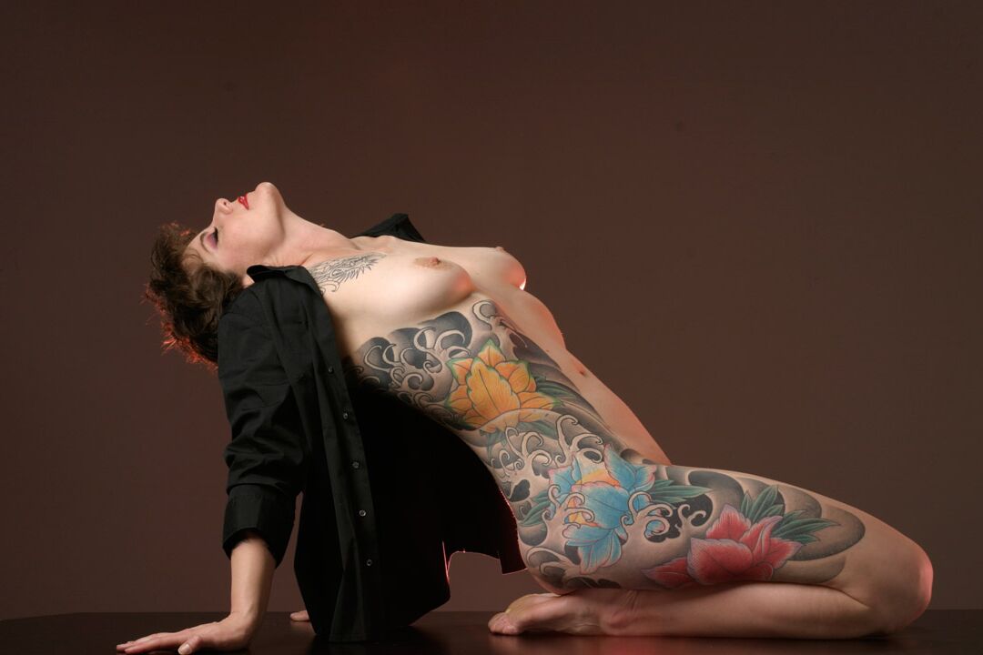 15P La mujer tatuada Michelle Aston realiza estupendas poses semidesnudas sobre una mesa