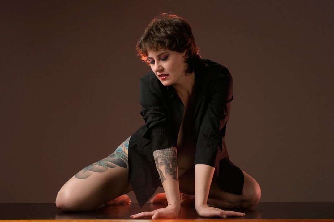 15P La mujer tatuada Michelle Aston realiza estupendas poses semidesnudas sobre una mesa