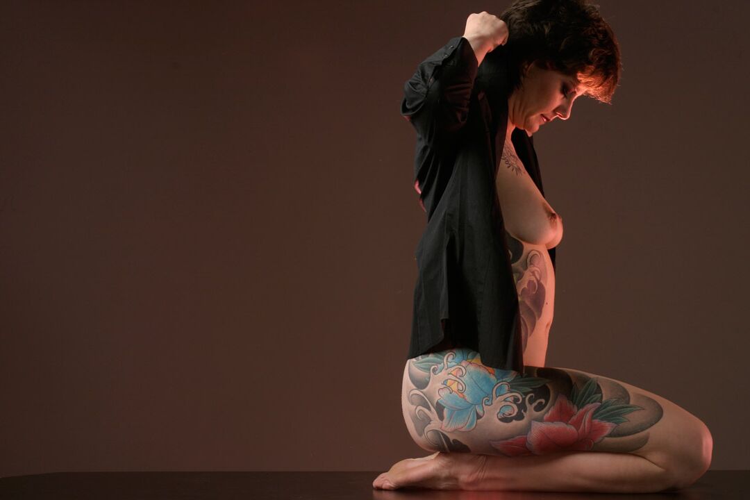 15P La mujer tatuada Michelle Aston realiza estupendas poses semidesnudas sobre una mesa