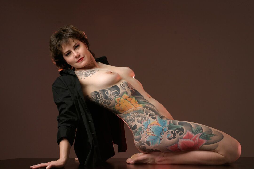 15P La mujer tatuada Michelle Aston realiza estupendas poses semidesnudas sobre una mesa